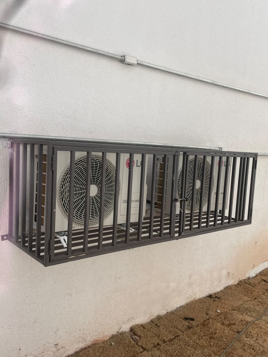 Grade de aço protegendo um ar-condicionado na parede